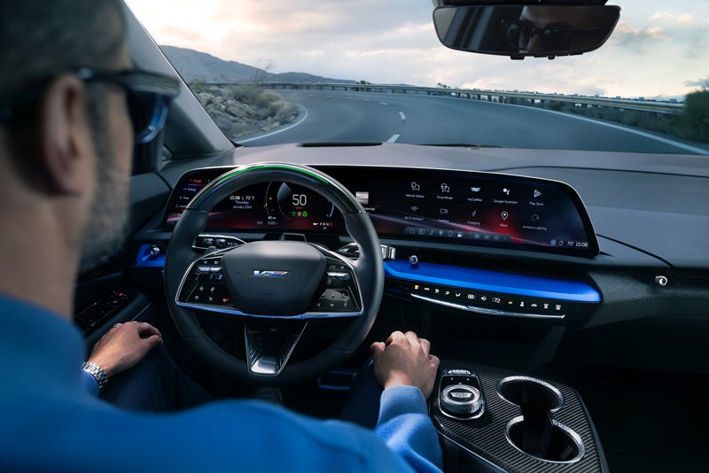 Front View of the 2026 OPTIQ-V Driving Through the Dusk Utilizing its Headlights | Joseph Cadillac in Florence KY